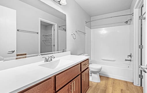 A white bathroom with a white sink and toilet.