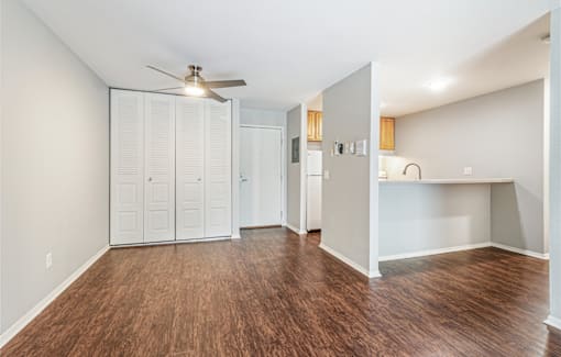 A room with a ceiling fan and wood flooring.