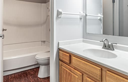 A white sink in a bathroom with wood cabinets.