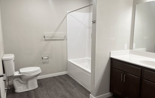A white toilet sits in a bathroom next to a walk-in shower.