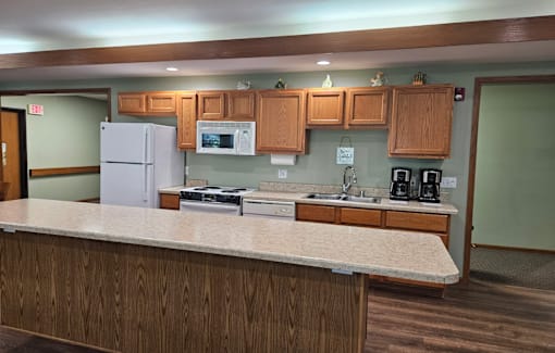 A kitchen with a white refrigerator and wooden cabinets.