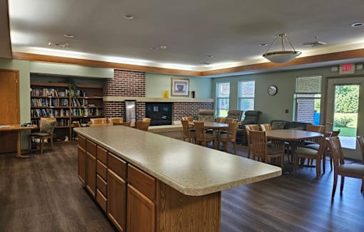 A room with a long counter and chairs on both sides.