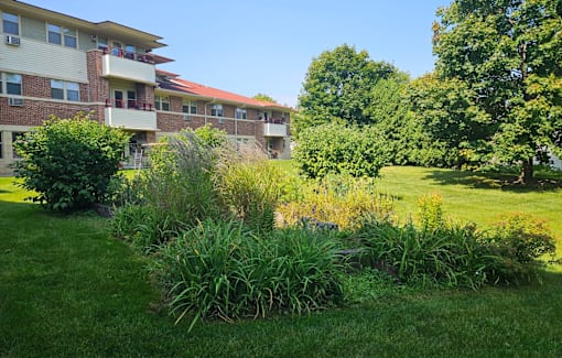 A grassy area in front of a building with a red roof.