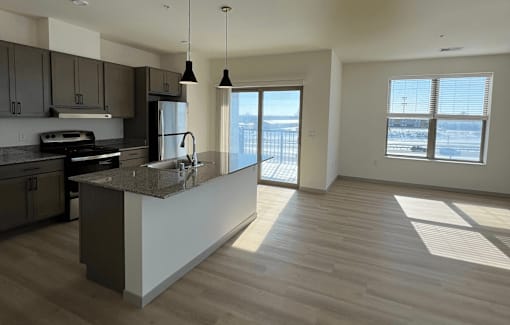 A kitchen with a marble countertop and a refrigerator.