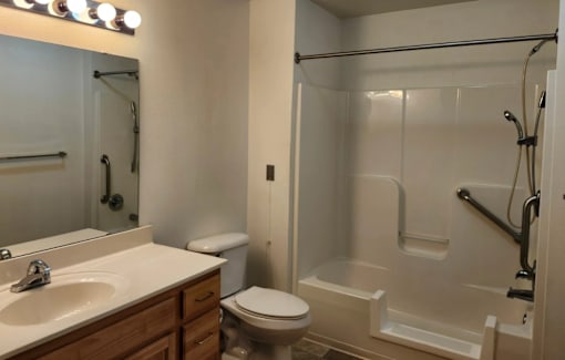 A bathroom with a toilet, sink, and shower.