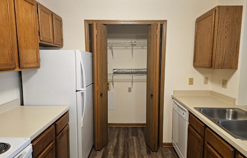 A kitchen with a white fridge and wooden cabinets.
