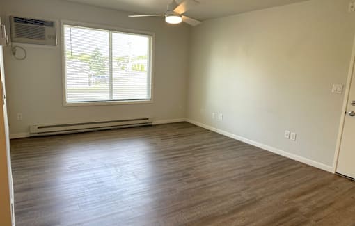 A room with a window and a ceiling fan.