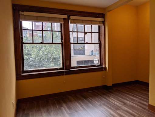 A room with a window and wooden floors.