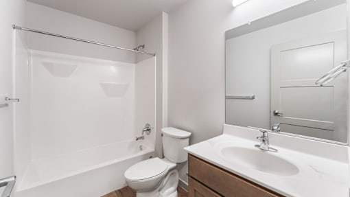 A white bathroom with a toilet, sink, and shower.