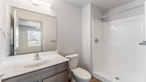 A bathroom with a toilet, sink, and shower.