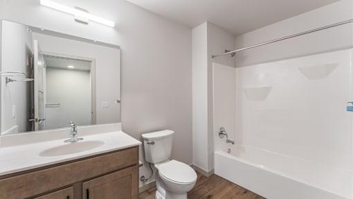 A white bathroom with a toilet, sink, and bathtub.