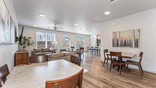A spacious living room with a large wooden table and chairs.