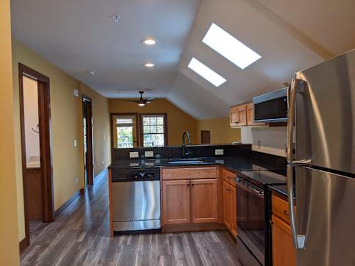 A kitchen with a refrigerator, microwave, and oven.