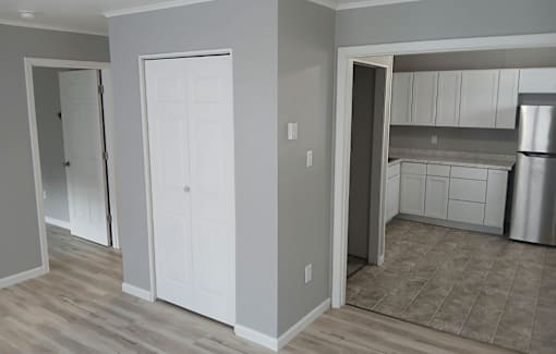 A kitchen with white cabinets and a refrigerator.