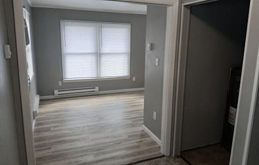 A room with a window and wooden floors.