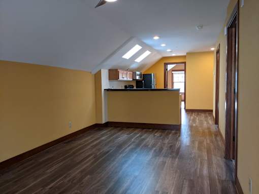 A room with wooden floors and a yellow wall.
