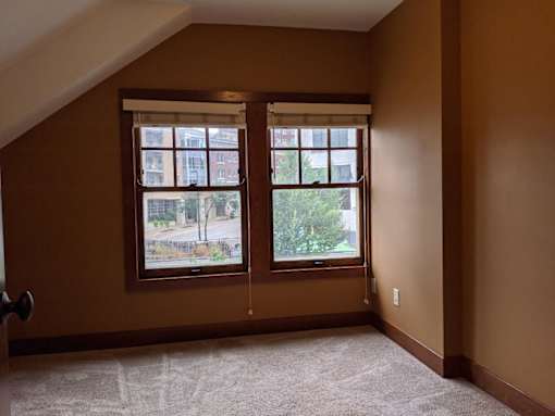 A room with a window and a carpet on the floor.