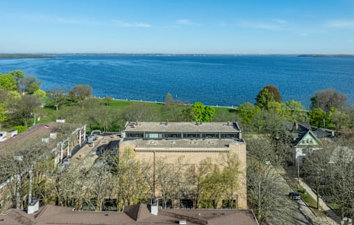 A large building with a flat roof is surrounded by trees.