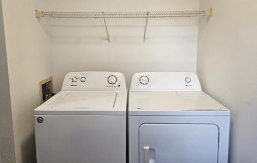 Two front loading washing machines in a small laundry room.