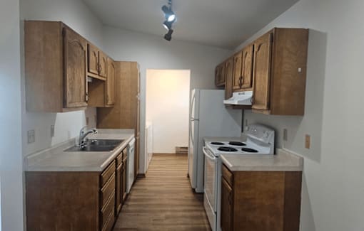 A kitchen with wooden cabinets and a white stove top oven.