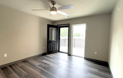 an empty living room with a ceiling fan
