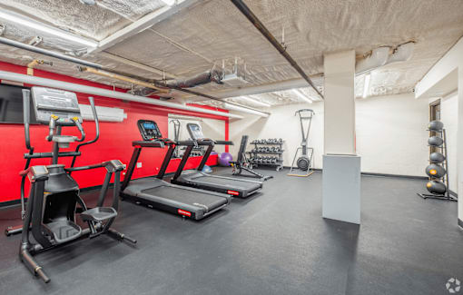 A gym with treadmills, elliptical machines, and other exercise equipment.
