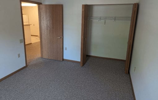 an empty room with a closet and an open door