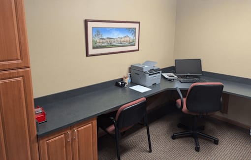 a desk with a computer and a printer on it