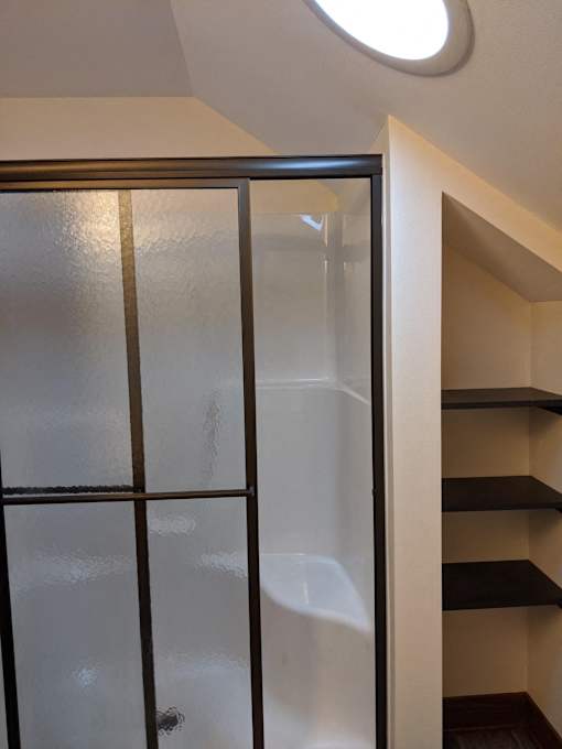 A glass door with a black frame is in the foreground.