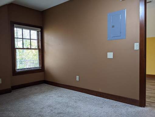 A room with brown walls and a window with blinds.