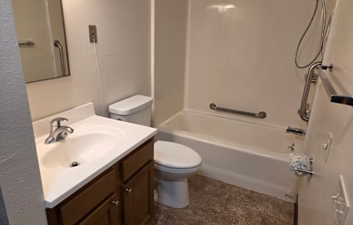 A bathroom with a toilet, sink, and bathtub.
