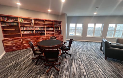 a conference room with a table and chairs and a bookshelf