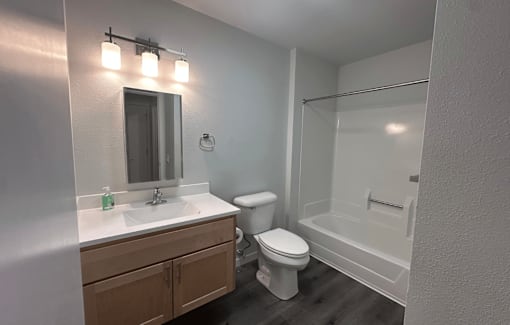 A bathroom with a toilet, sink, and shower.