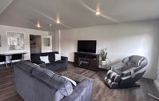 A living room with a grey couch and a black chair.
