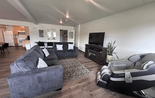 A living room with a grey couch and a black and white recliner.