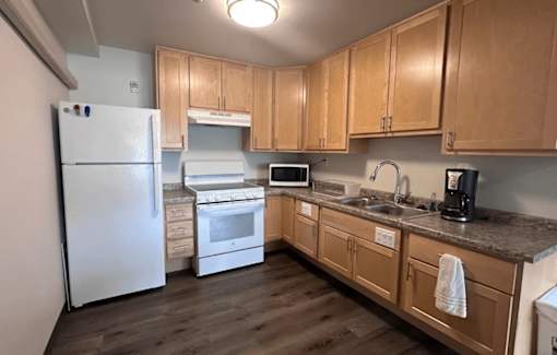 A kitchen with wooden cabinets and a white refrigerator.