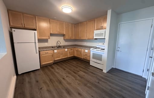 A kitchen with wooden cabinets and a white refrigerator.