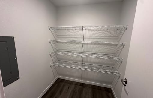 A walk in closet with shelves and a door.
