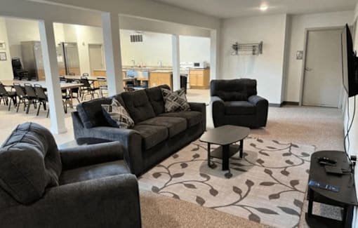 A living room with a grey couch and a black armchair.