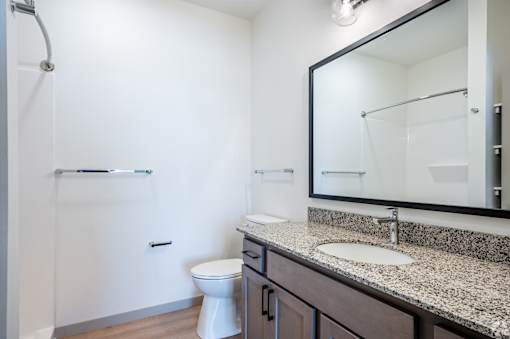 A white toilet sits in a bathroom next to a sink.
