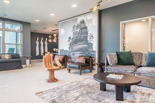A living room with a grey couch, a wooden chair, and a coffee table.