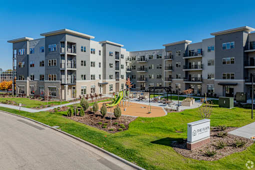 Apartment complex named The Flats with a playground in front.