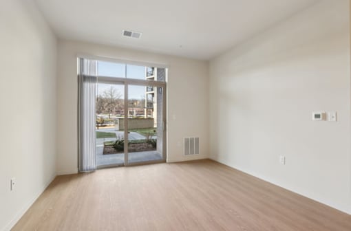 A room with a sliding glass door leading to a balcony.