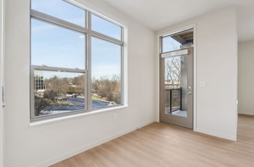 A room with a large window overlooking a parking lot.