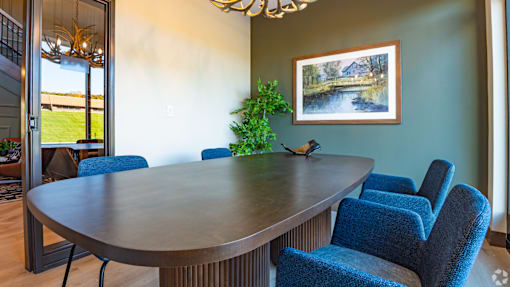 A dining room with a round table and blue chairs.