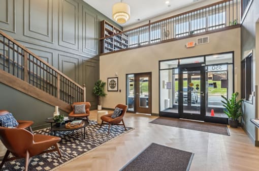 A lobby with a staircase and a glass door.