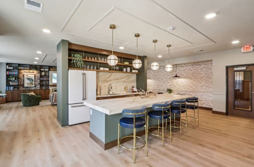 A kitchen with a bar area and a white fridge.