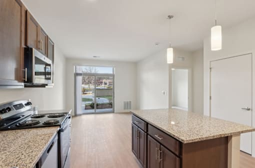 A kitchen with granite countertops and wooden cabinets.