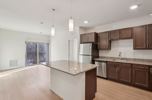 A kitchen with brown cabinets and a granite countertop.