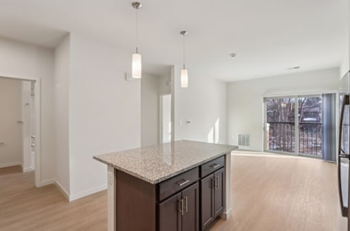 A kitchen with a granite countertop and wooden cabinets.